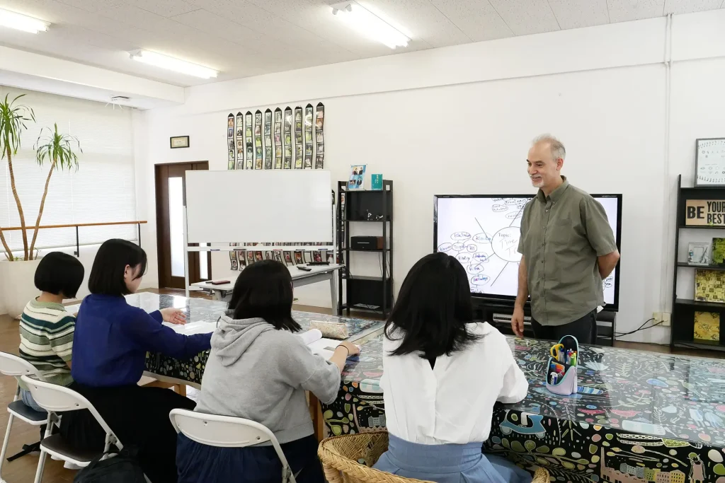 AIE国際高等学校 神戸キャンパスの少人数制クラスで、外国人講師による実践的な英語の授業を受ける生徒たちの様子。